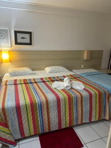 a hotel room with two beds with towels on them at Flat Beach Class Resort Muro Alto in Porto De Galinhas