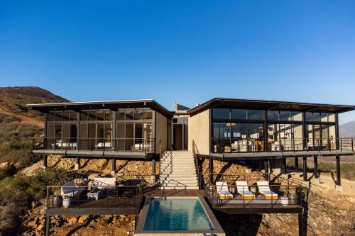 a house on the side of a hill with a pool at Casa Finch, Valle de Guadalupe in Valle de Guadalupe