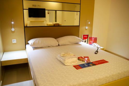 a hotel room with a bed with towels and a mirror at Hotel Sogo Dasmariñas Cavite in Dasmariñas