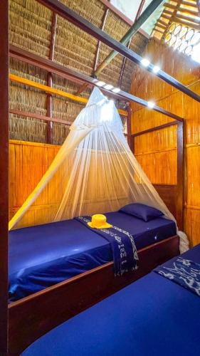 a bedroom with a bed with a mosquito net at Sten Lodge in Labuan Bajo