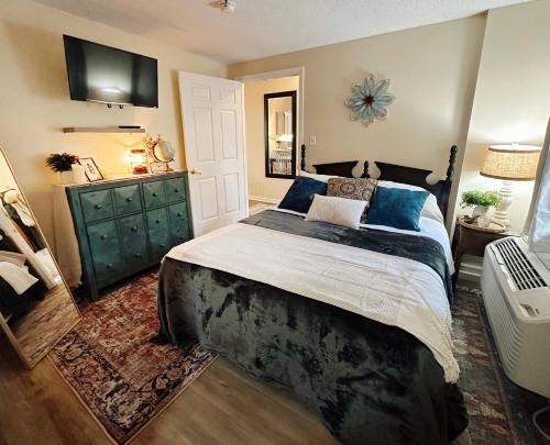 a bedroom with a large bed and a dresser at Smoky Hue in Gatlinburg