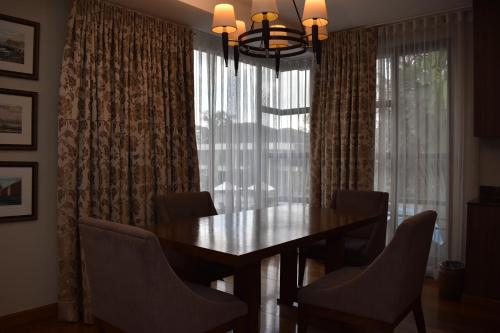 a dining room with a table and chairs and a window at Holiday Inn & Suites Batangas LimaPark by IHG in Batangas City