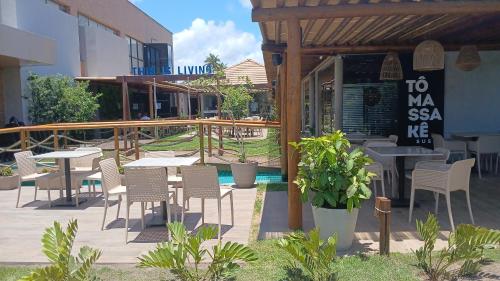 a patio with tables and chairs outside of a restaurant at MALIA MURO ALTO STUDIO 300m DO MAR in Porto De Galinhas