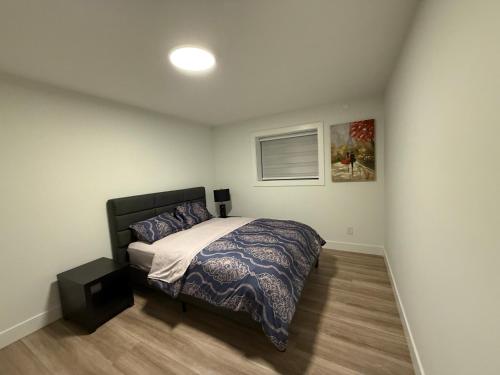 a bedroom with a bed and a picture on the wall at Calm & Cozy Private Suite in Surrey