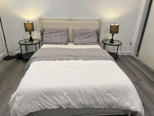 a bedroom with a large white bed with two lamps at 便捷宜居的独立房子 in Baldwin Park