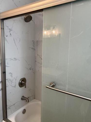 a bathroom with a shower with a glass door at 便捷宜居的独立房子 in Baldwin Park