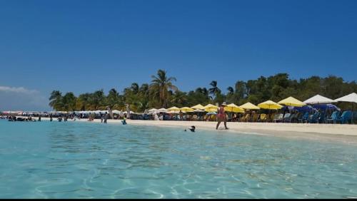 a group of people on a beach with umbrellas at Apartamento Punta Brava en el Centro de Tucacas in Tucacas