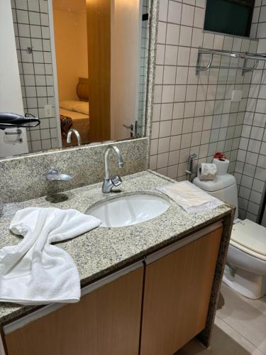 a bathroom with a sink and a toilet at Flat Beach Class Resort Muro Alto in Porto De Galinhas