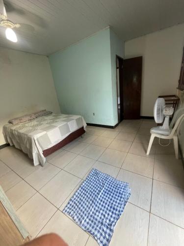 una camera da letto con un letto e una sedia di Casa ao ar livre ad Aracaju