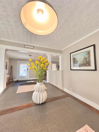 a room with a vase with yellow flowers in it at Private Room in an Elegant Home- Convenient to Downtown Indianapolis in Indianapolis