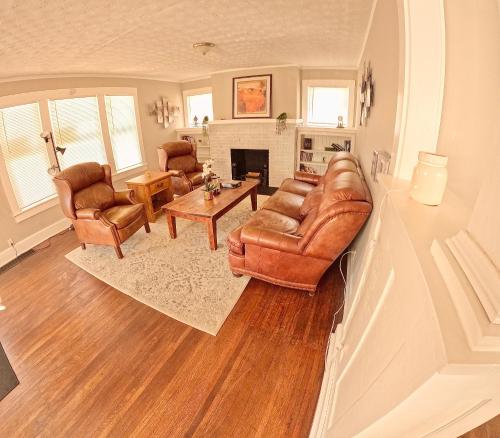 a living room with leather furniture and a fireplace at Private Room in an Elegant Home- Convenient to Downtown Indianapolis in Indianapolis