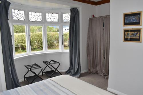 a bedroom with two chairs in front of a window at Te Hoiere Guesthouse in Havelock