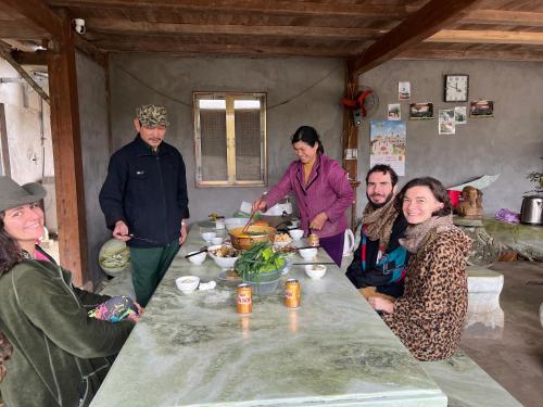 a group of people sitting around a table with food at Fish Farm Homestay in Yên Bái