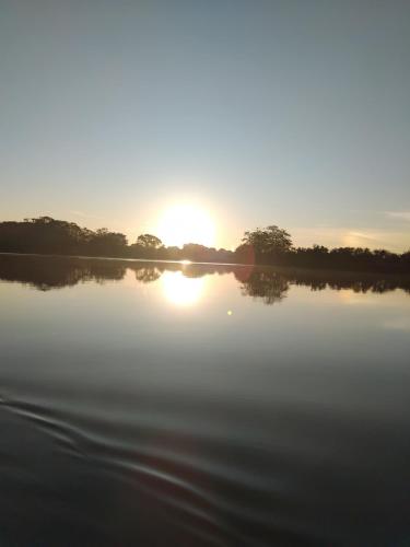 a sunset over a body of water with trees in the background at Ethili Lake view & Safari Camp in Wellawaya