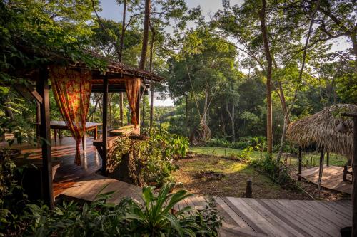 a wooden deck with a hut in a forest at TerrAmor Ecoliving in Alter do Chao