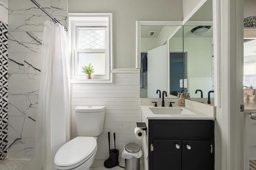 a white bathroom with a toilet and a sink at Elegant Townhome Retreat with King Bed Near I-10, Capitol, FSU & FAMU in Tallahassee