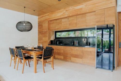 a dining room with a table and chairs at 99 Villa Suite - Modern Bedrooms with Dining Area & Enormous Pool in Kerobokan