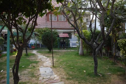a garden with trees in front of a house at The Villa- a Home away from Home in Ajmer