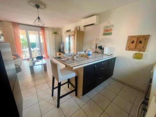 - une cuisine avec un îlot au milieu d'une pièce dans l'établissement Villa 4/6 pers climatisée avec piscine, WiFi & parking proche plage - FR-1-796-85, à Gruissan