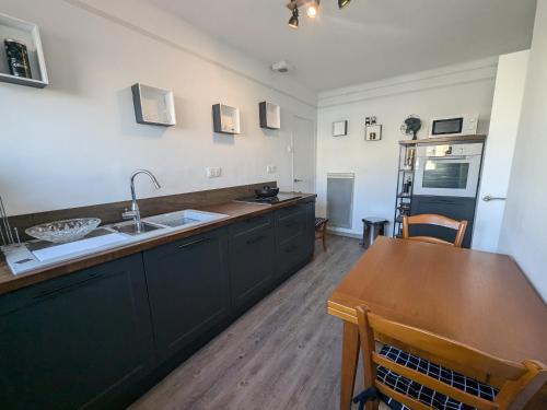 - une cuisine avec un évier et une table en bois dans l'établissement Maison T4 110m² avec jardin clos, à 1500m de la plage - FR-1-797-60, à Port-la-Nouvelle