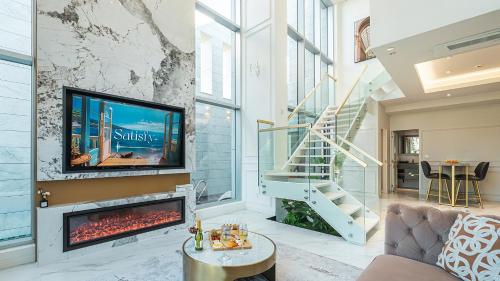 a living room with a fireplace and a tv at Eudaimonia Poolvilla Jeju 에다모니아 함덕풀빌라 in Jeju