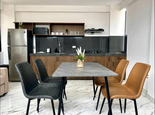 Una cocina con mesa y sillas y un refrigerador. en Dpto de estreno centro de Tacna 303, en Tacna