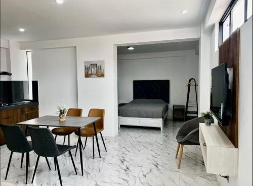 Una sala de estar con una mesa y sillas y una cama. en Dpto de estreno centro de Tacna 303, en Tacna