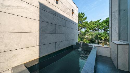 a swimming pool in the side of a building at Eudaimonia Poolvilla Jeju 에다모니아 함덕풀빌라 in Jeju