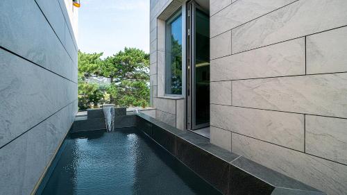 a water fountain in the side of a building at Eudaimonia Poolvilla Jeju 에다모니아 함덕풀빌라 in Jeju