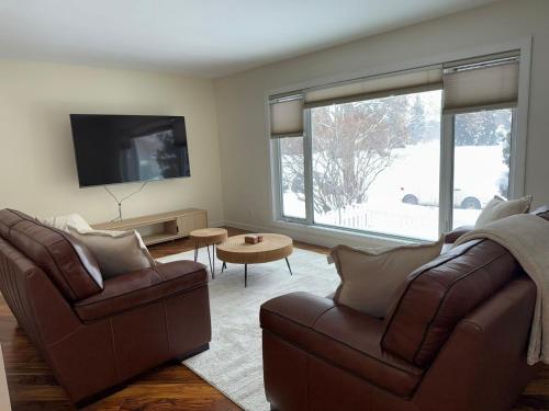 a living room with two couches and a tv at 2Bed Bright & Stylish Ritchie Urban Retreat in Edmonton