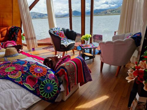 een slaapkamer met een bed en uitzicht op het water bij Titicaca Alpina HARMONY lodge in Puno