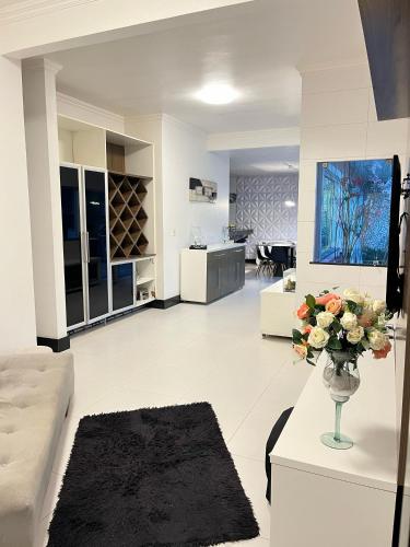 a living room with a vase of flowers on a table at COP 30 Belém - Casa ampla de alto padrão em condomínio bem localizado in Belém