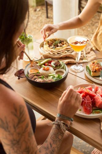 a woman sitting at a table with a plate of food at Amaroo Hikkaduwa in Hikkaduwa