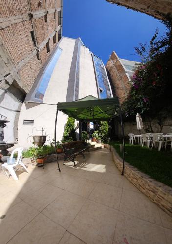 a patio with a green tent and chairs and a building at El Seminario Hospedaje in Cajamarca
