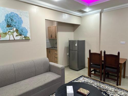 a living room with a couch and a refrigerator at Pyramiza Hotel Al Mangaf فندق بيراميـــزا المنقف in Kuwait