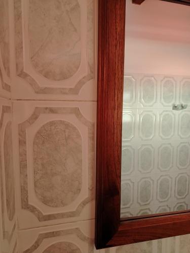 a mirror with a wooden frame next to a wall at Villa Girasol in Villa de Leyva