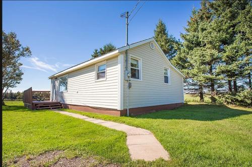 a small white house in a field of grass at Canadas Best Value Inn & Suites Summerside in Summerside