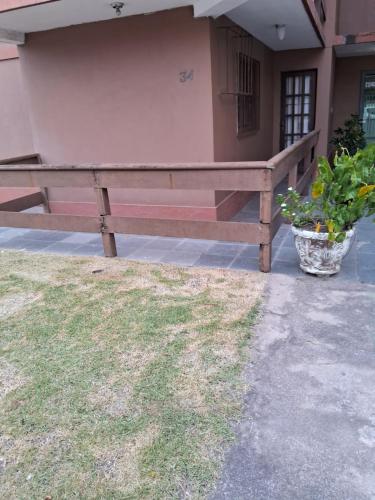 a wooden bench sitting in front of a building at Apartamento charmoso in Rio das Ostras