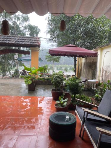 un patio con mesa, sombrilla y plantas en Chu hostel Tam Coc, en Vũ Lâm