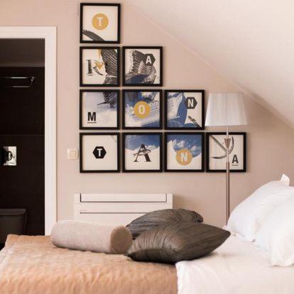 a room with a bed with pictures on the wall at Heritage hotel Viganj in Orebić
