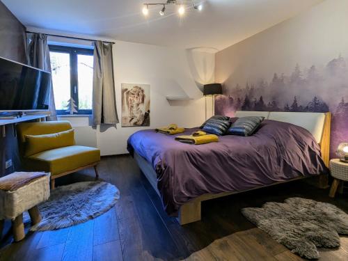 une chambre avec un grand lit et une chaise dans l'établissement Évasion montagne à Gérardmer avec terrasse et parking - FR-1-589-793, à Gérardmer