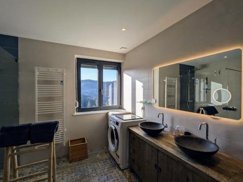une salle de bain avec deux lavabos et un grand miroir dans l'établissement Évasion montagne à Gérardmer avec terrasse et parking - FR-1-589-793, à Gérardmer