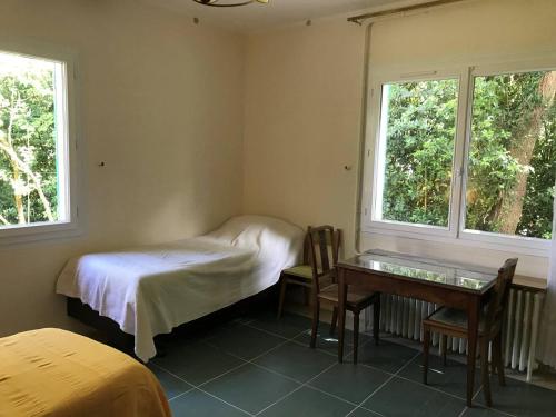 Cette chambre comprend un lit, un bureau et 2 fenêtres. dans l'établissement Villa 2* à Vaux-sur-Mer - Jardin et Animaux admis - FR-1-738-43, à Vaux-sur-Mer