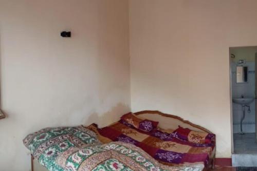 a bed in a room with a blanket on it at Purohit Lodge B&B by StayApart in Gupta Kāshi