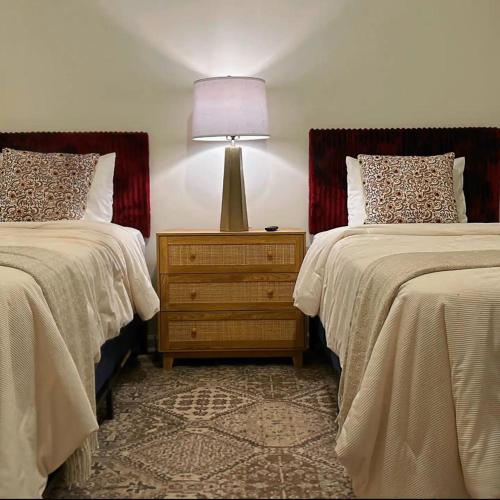 a bedroom with two beds and a lamp on a night stand at Walk to GWCC, Mercedes-Benz in Atlanta