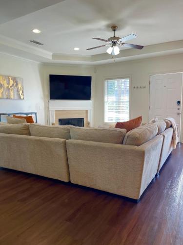 a large couch in a living room with a ceiling fan at Walk to GWCC, Mercedes-Benz in Atlanta
