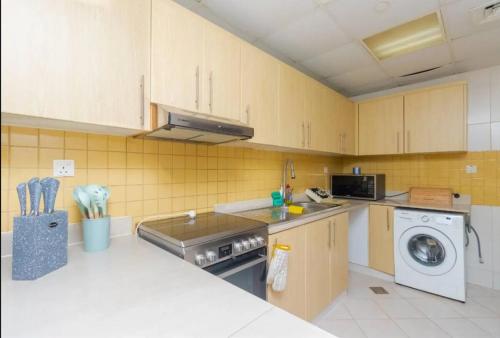 a kitchen with a washing machine and a washer at One Bedroom apartment on the beach! For you and your family in Ras al Khaimah