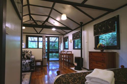a bedroom with a bed and a living room at Tudor Cottages in Mount Dandenong