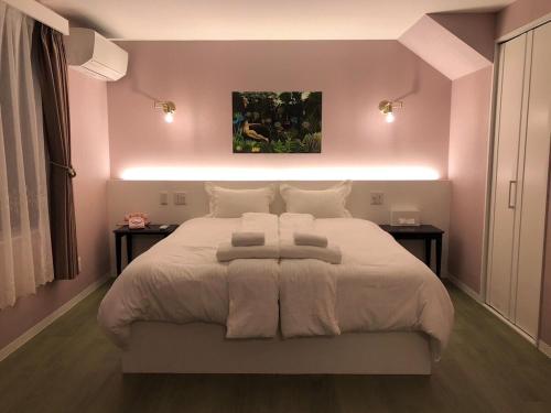 a bedroom with a large white bed with two tables at Mariposa Sea and Starry Garden Villa in Ishigaki Island