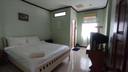 a bedroom with a bed and a television in it at บ้านบำรุงสุข in Chiang Khan